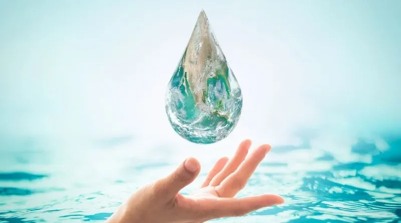 Grande gota d'água sobre mão com fundo de mar