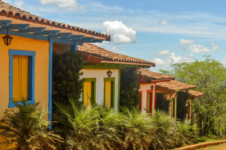 Casas coloniais coloridas com telhados de cerâmica na vila histórica de Lavras Novas, Minas Gerais.
