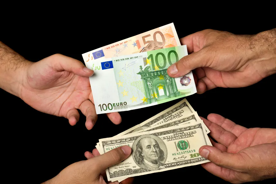 Câmbio de moedas: mãos trocando notas de euro e dólar. Negócios financeiros, investimento e economia global.